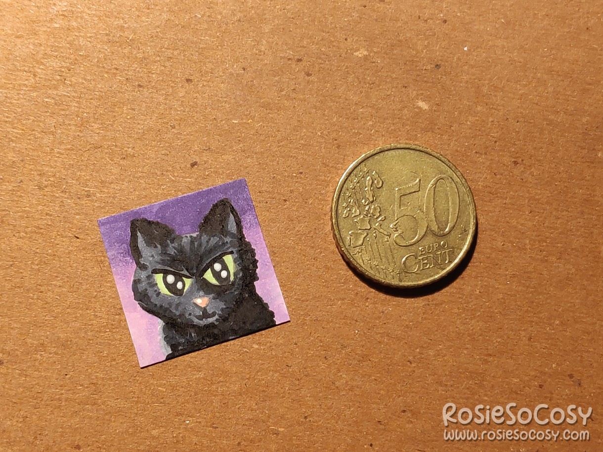 It's a tiny illustration of a black cat, about the size of an inch, and next to it is a 50 Euro cent coin for comparison.